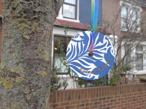 pretty sign hanging from rowan tree outside house